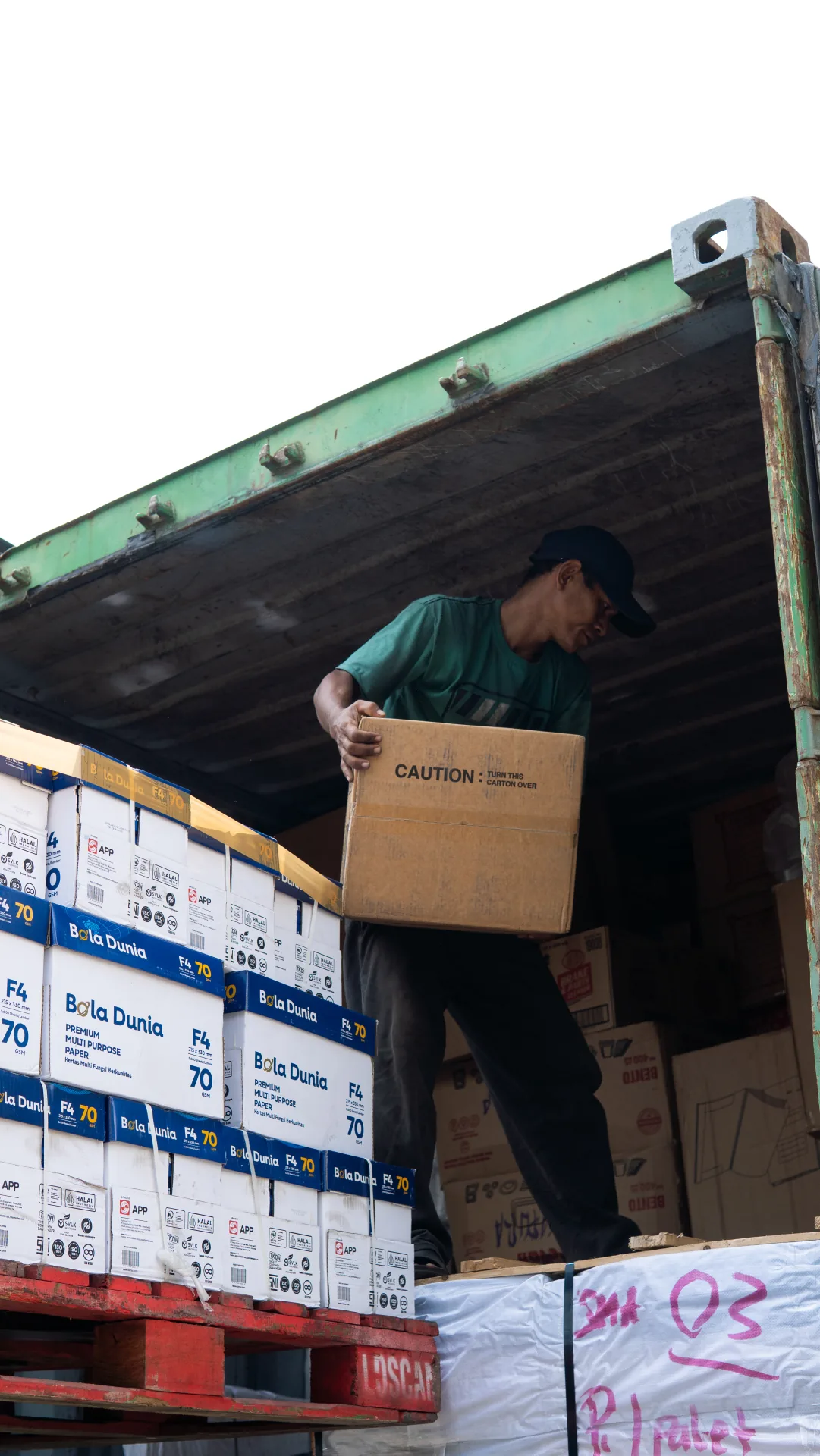 Worker unloading cartons from a container