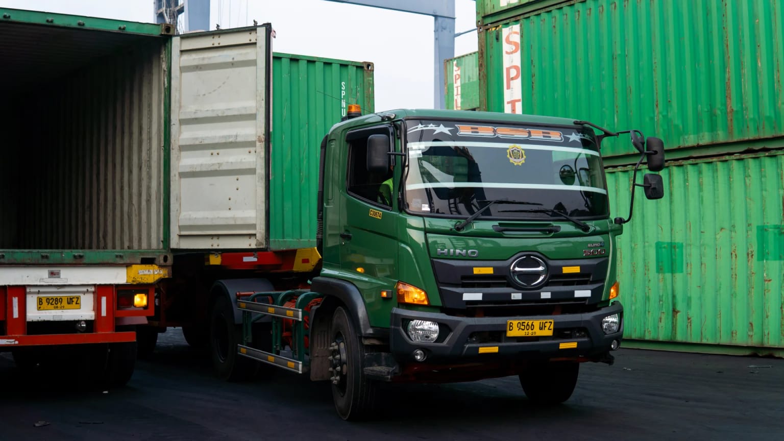 Green BSB Hino truck hauling a container at the port yard