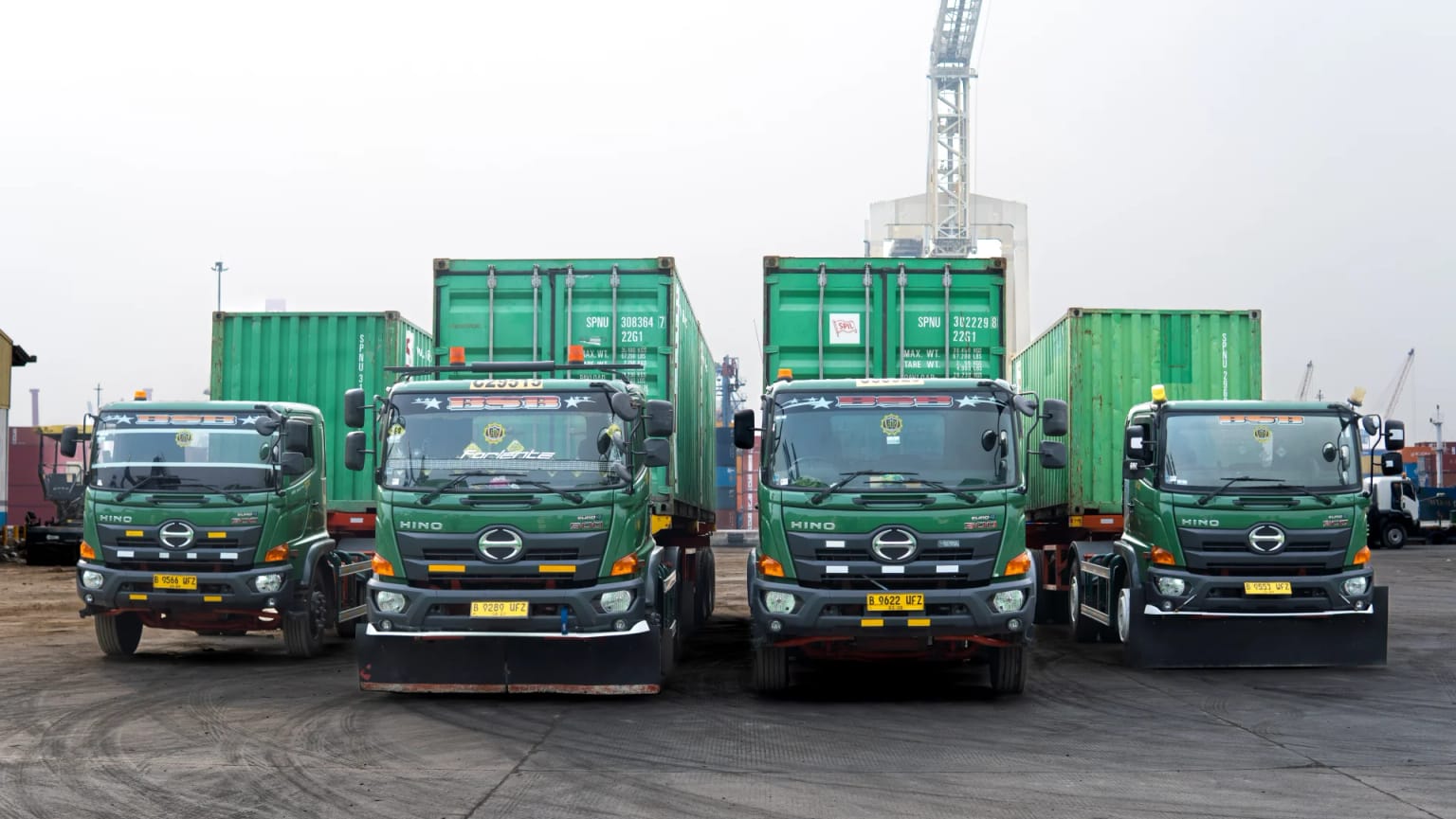 Row of four BSB Hino trucks parked at the port yard